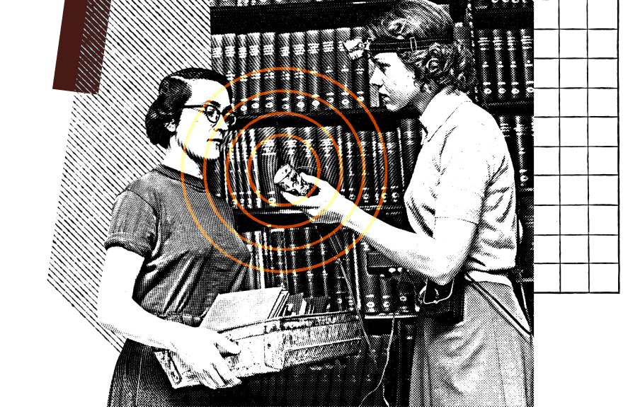 Women in library with one holding up microphone for the other to speak