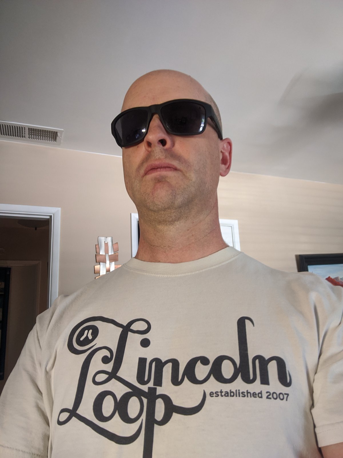 Brian Luft wearing sunglasses and wearing a "Lincoln Loop" t-shirt